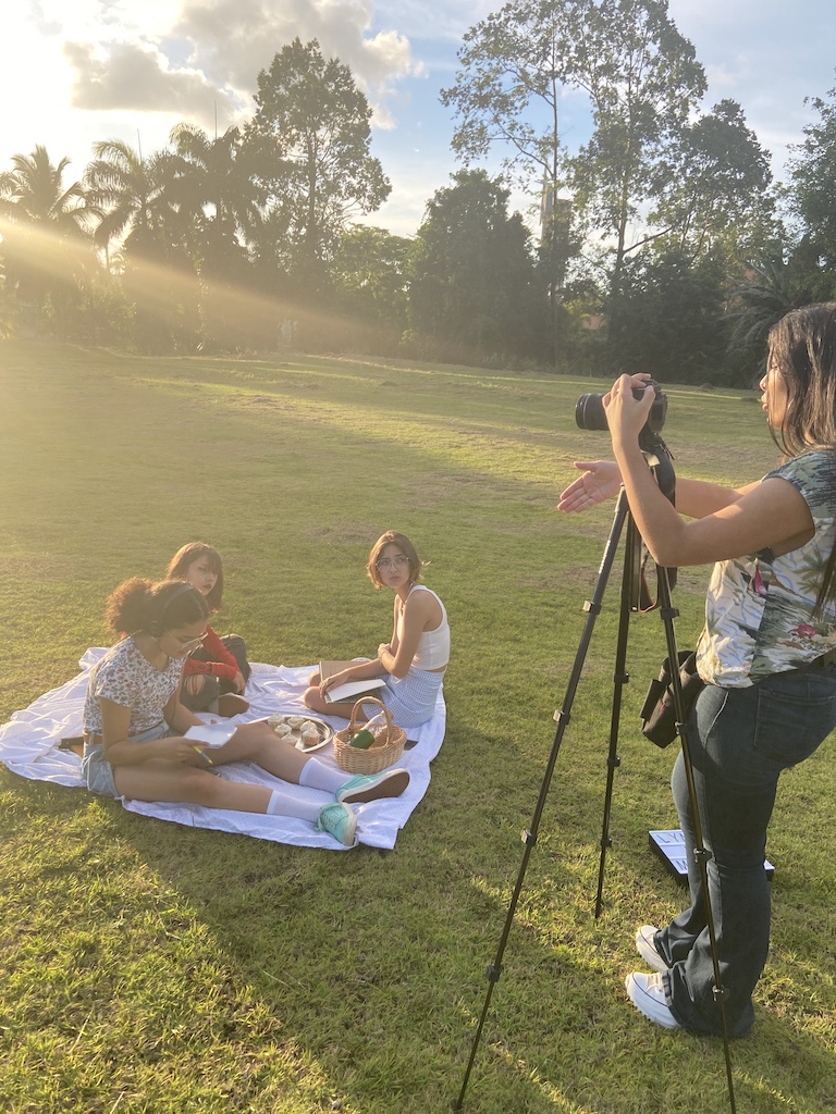Isabella Gierbolini filming three actresses on a picnic blanket outdoors